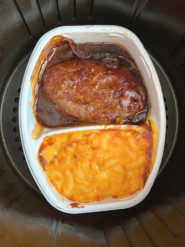 heated Salisbury Steak dinner inside an air fryer basket