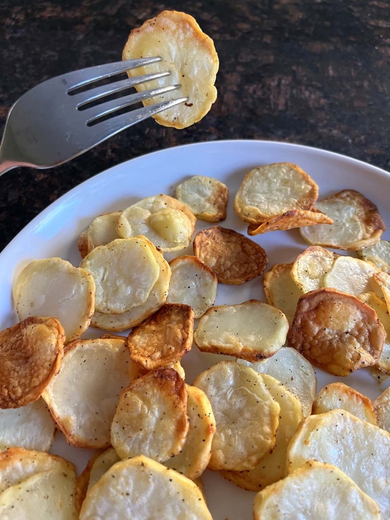 fork holding piece of sliced potato