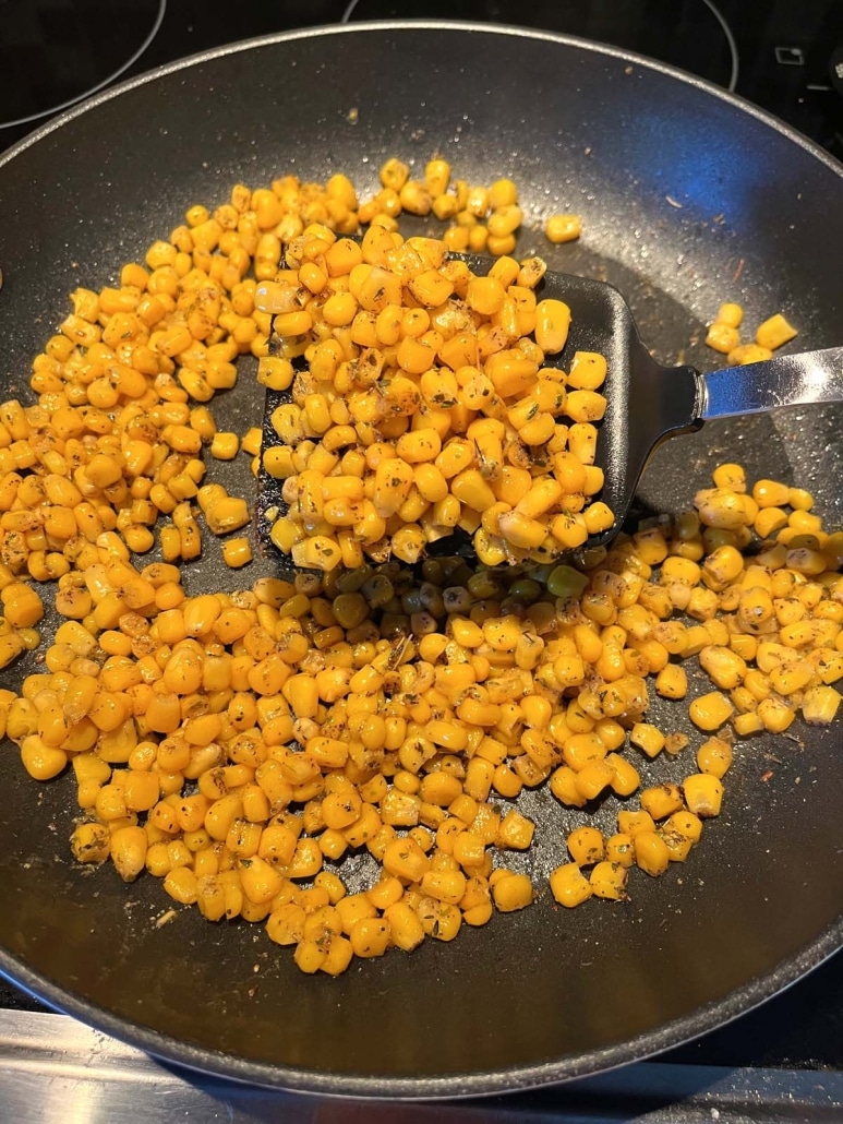 spatula stirring up corn in skillet