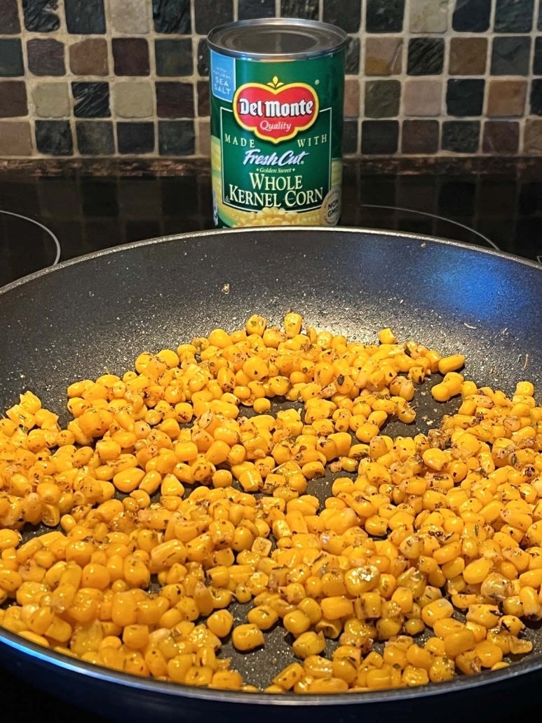 skillet of cooked corn next to a can of corn