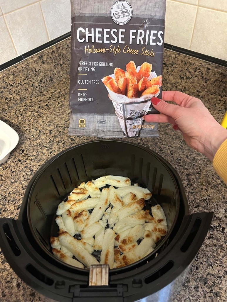 hand holding package of Aldi Cheese Fries next to cheese fries in an air fryer