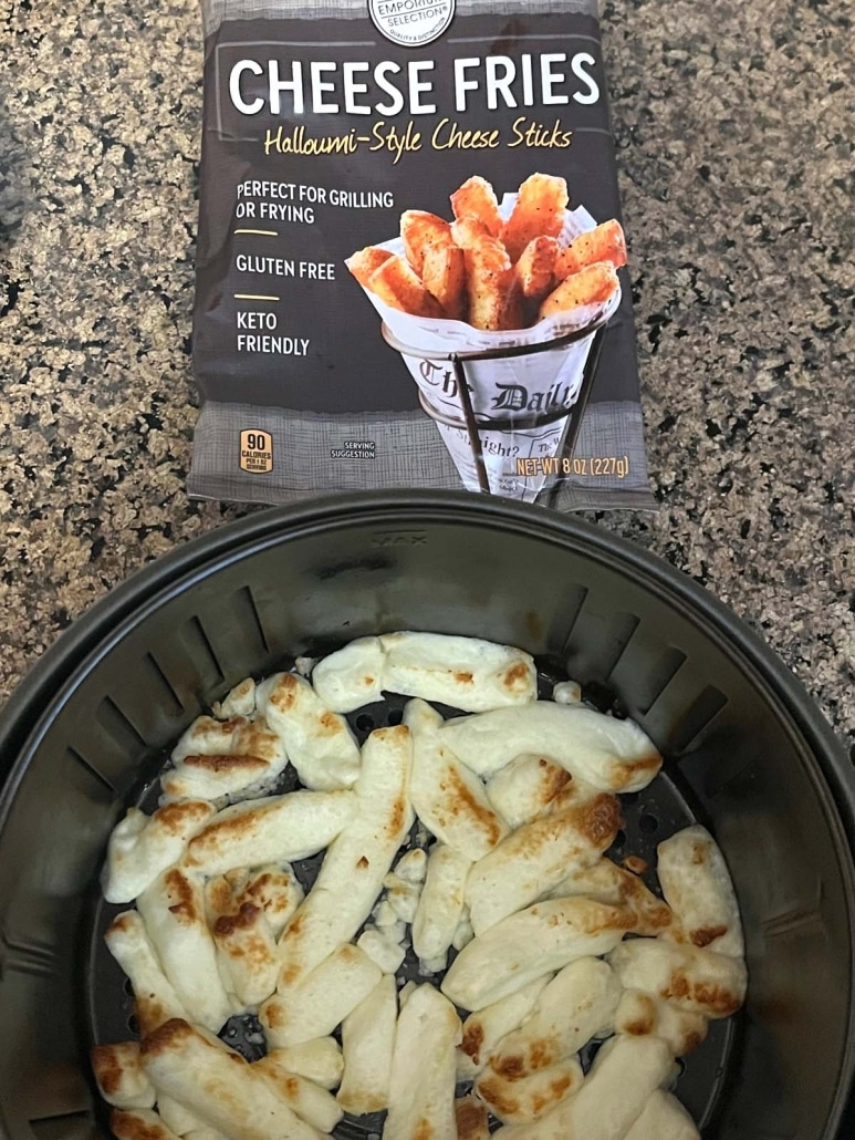 pack of frozen Aldi cheese fries next to an air fryer basket containing roasted cheese fries