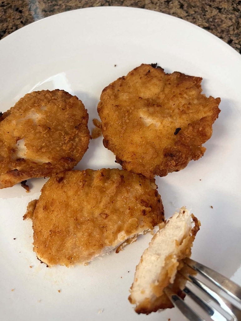 air fryer Aldi red bag chicken on a plate with a fork holding a piece