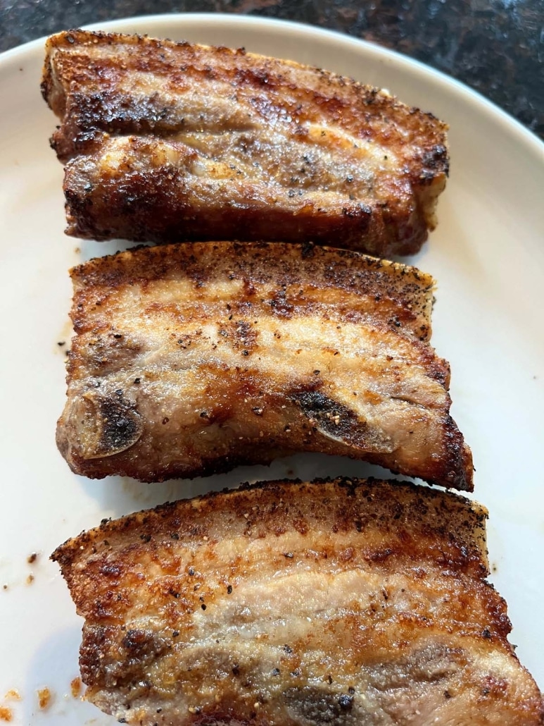 seasoned and crisp pork belly slices on a plate