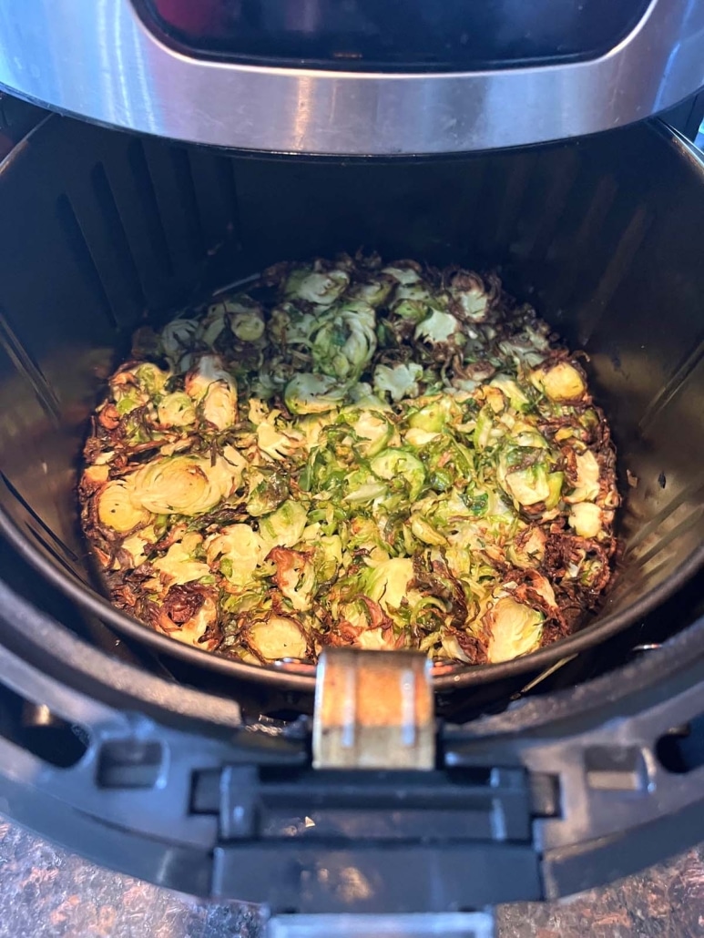 air fryer opened to show roasted brussels sprouts inside