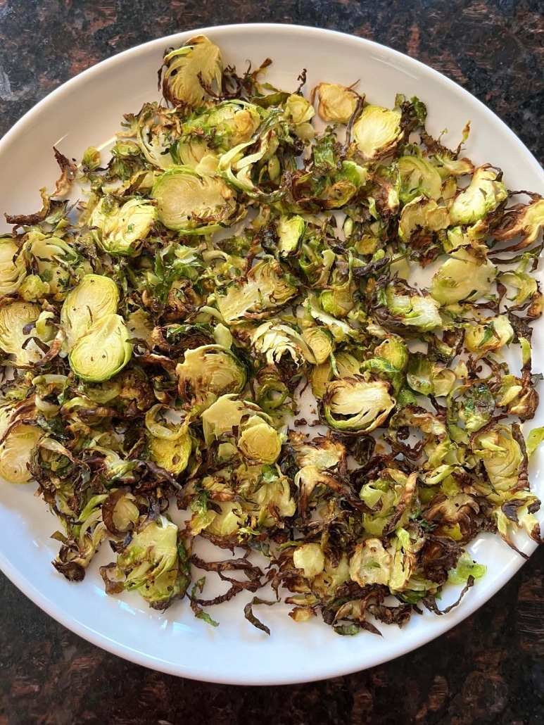 plate of sliced and seasoned Air Fryer Brussels Sprouts