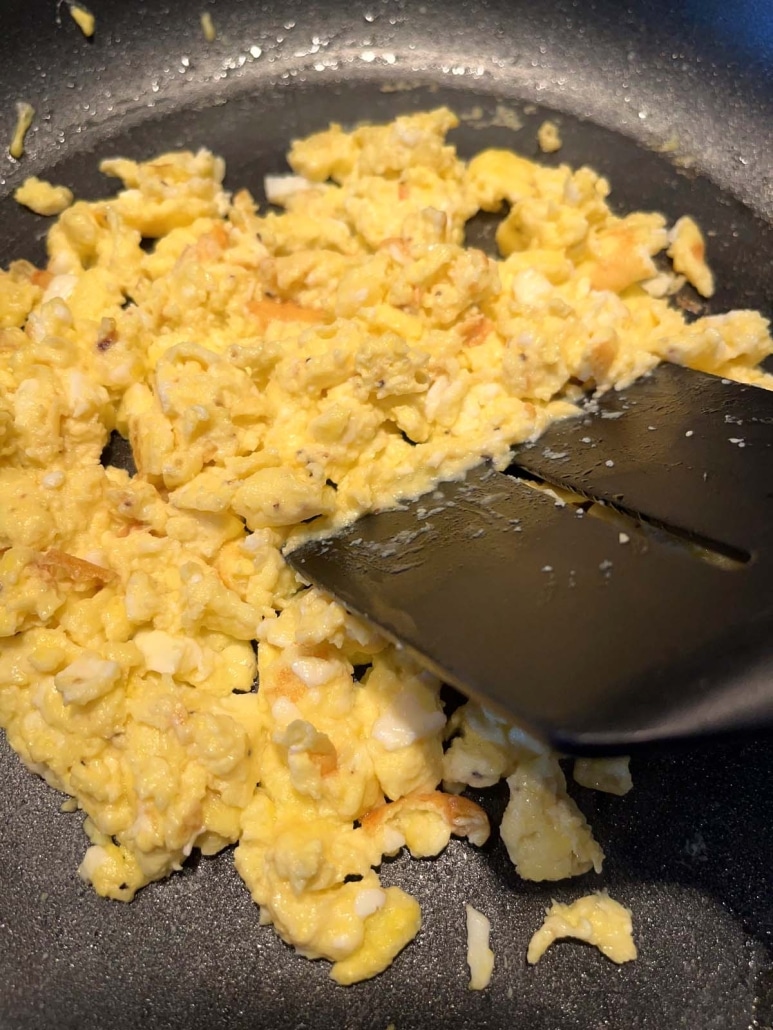 spatula mixing up eggs with cottage cheese