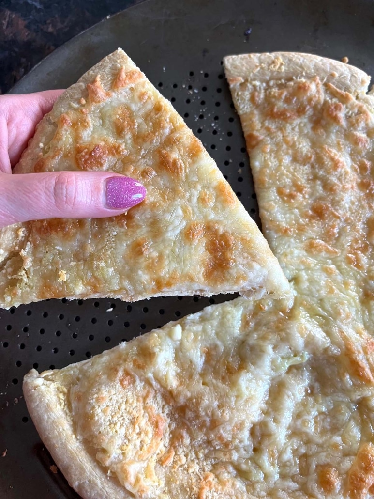 hand pulling a slice of Garlic Pizza off the dish
