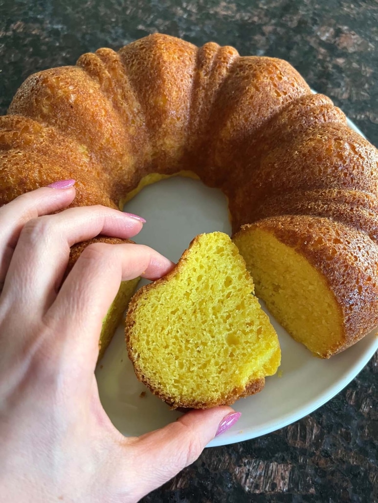 hand holding slice of moist lemon bundt cake