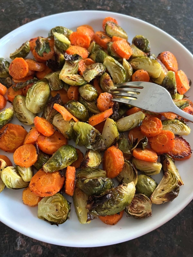 fork holding piece of tender Roasted Brussels Sprouts And Carrots