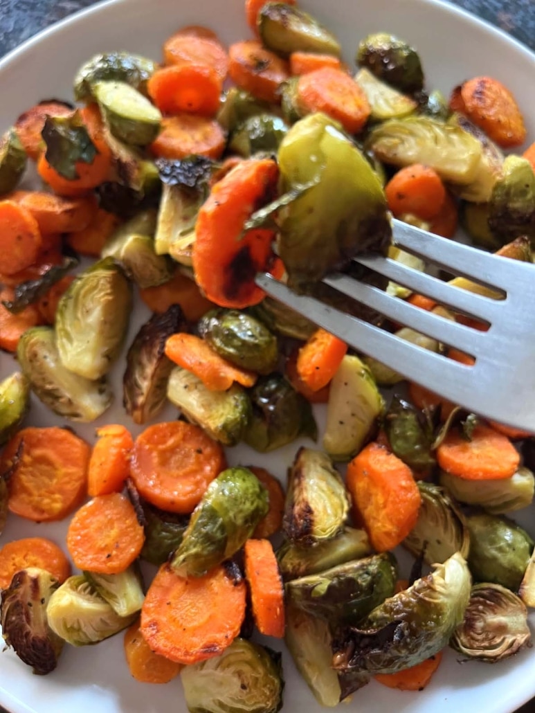 fork holding a bite of Roasted Brussels Sprouts And Carrots