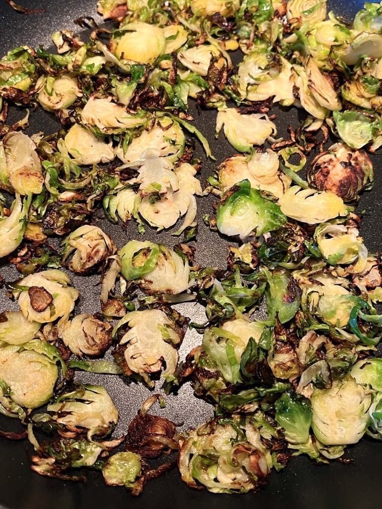 close-up of shaved Brussels sprouts sautéing in a pan