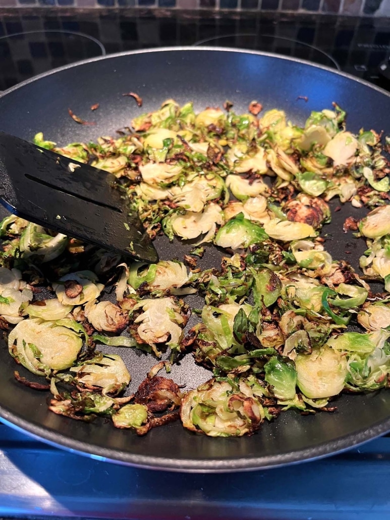 using a spatula to mix up Sauteed Shaved Brussels Sprouts
