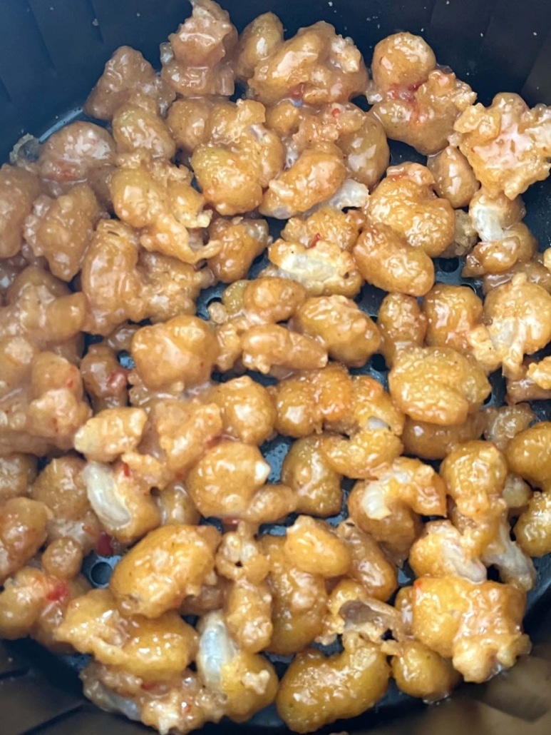 crispy bang bang shrimp in the basket of an air fryer