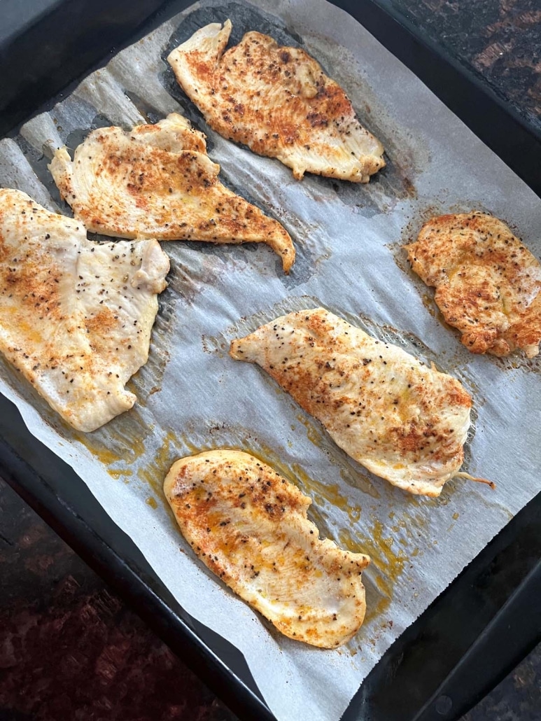 baking sheet with lightly seasoned chicken cutlets