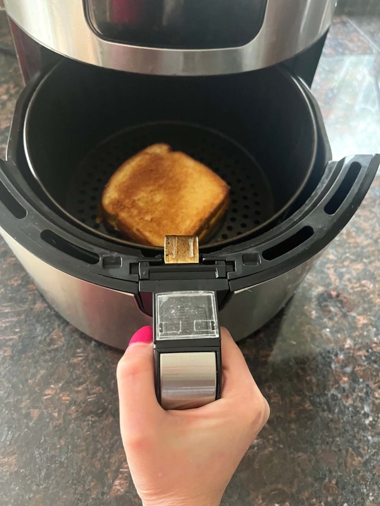air fryer opened up to show grilled sandwich inside