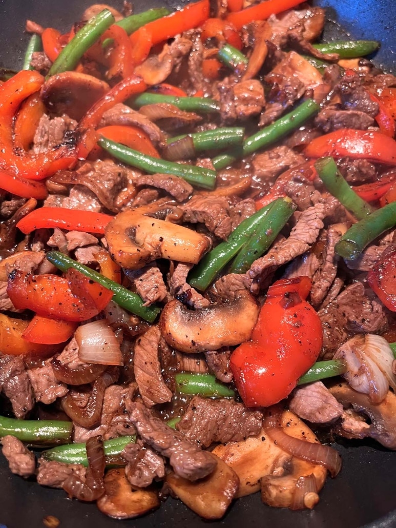 colorful vegetables and juicy sirloin steak in a skillet