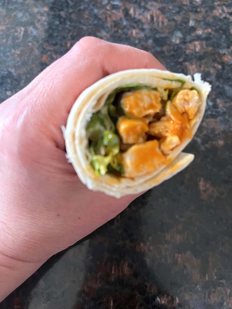 hand holding a sliced Buffalo Chicken Wrap