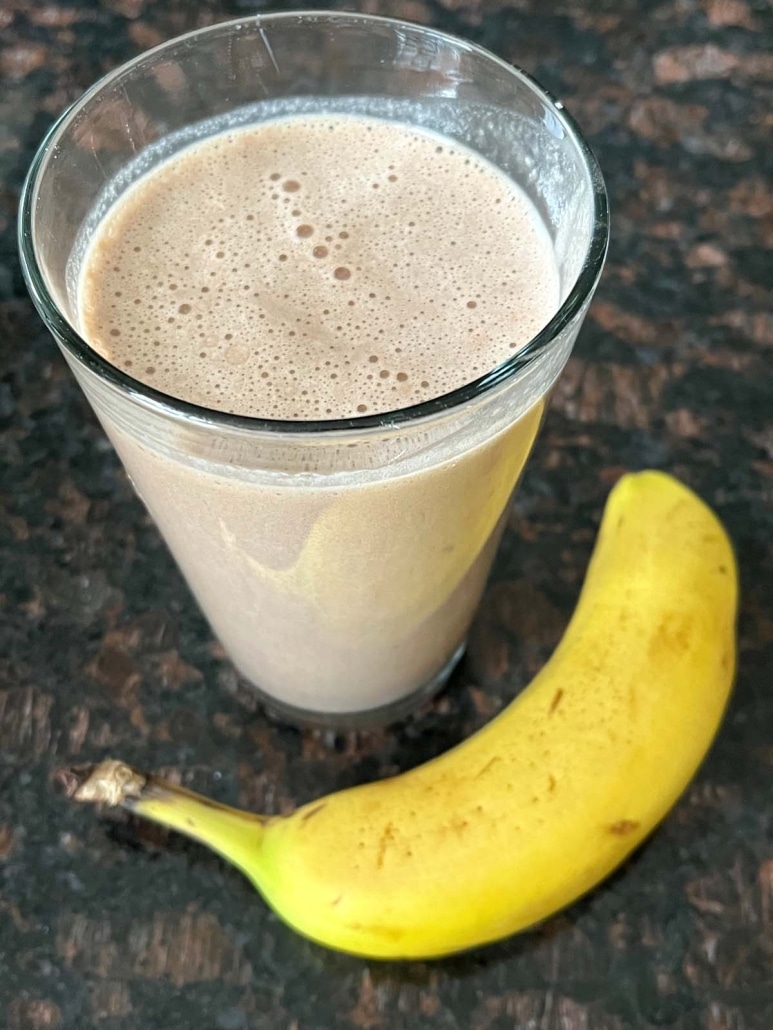 cup of a Chocolate Banana Protein Shake with banana next to it