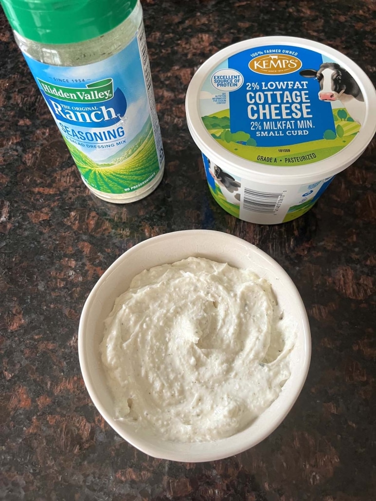 bowl of smooth and creamy Cottage Cheese Ranch Dip next to ranch seasoning and cottage cheese