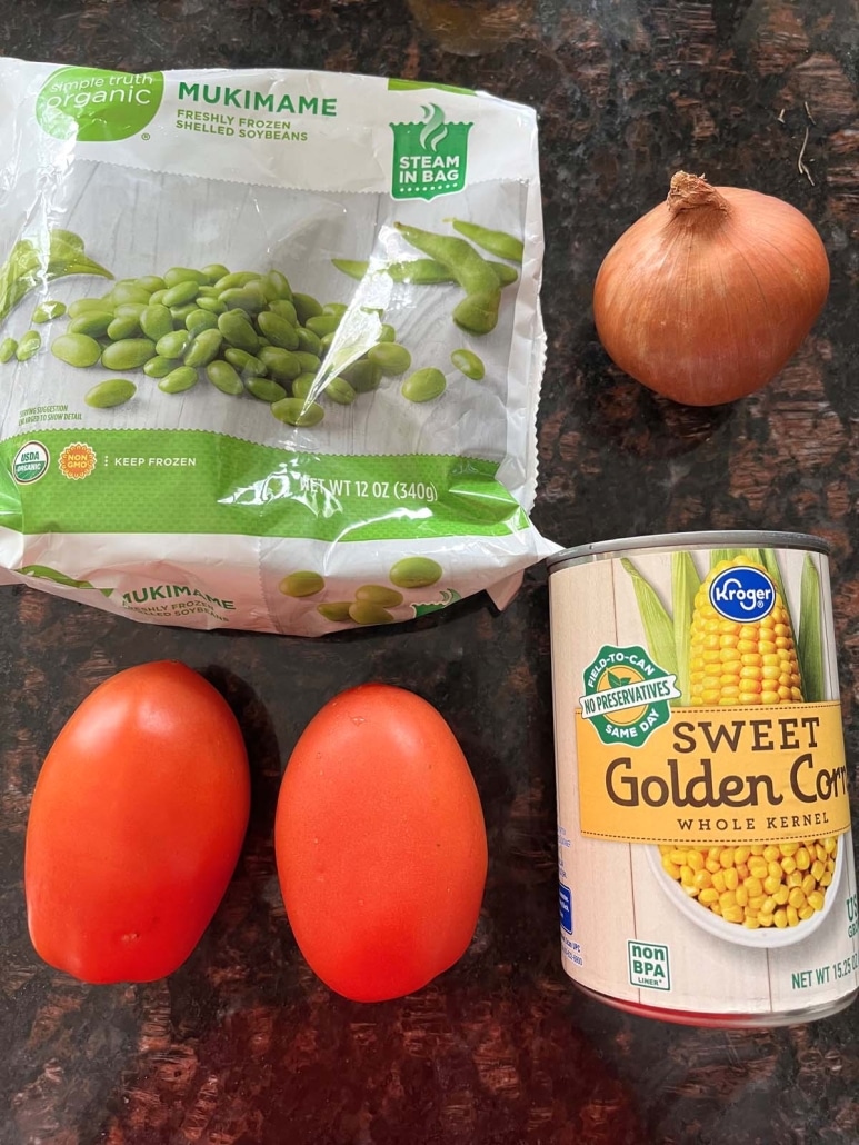 a package of edamame, an onion, 2 tomatoes, and a can of corn