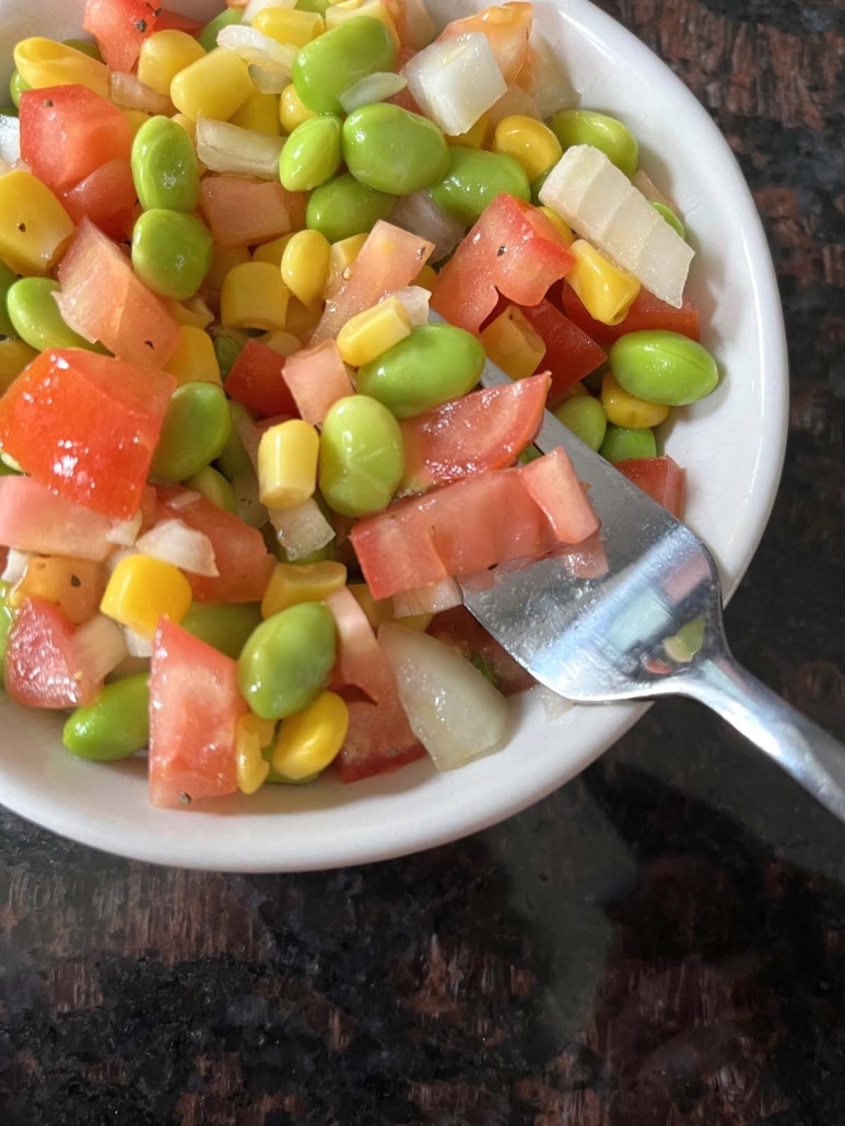 fork in a bowl of fresh and healthy Edamame Salad
