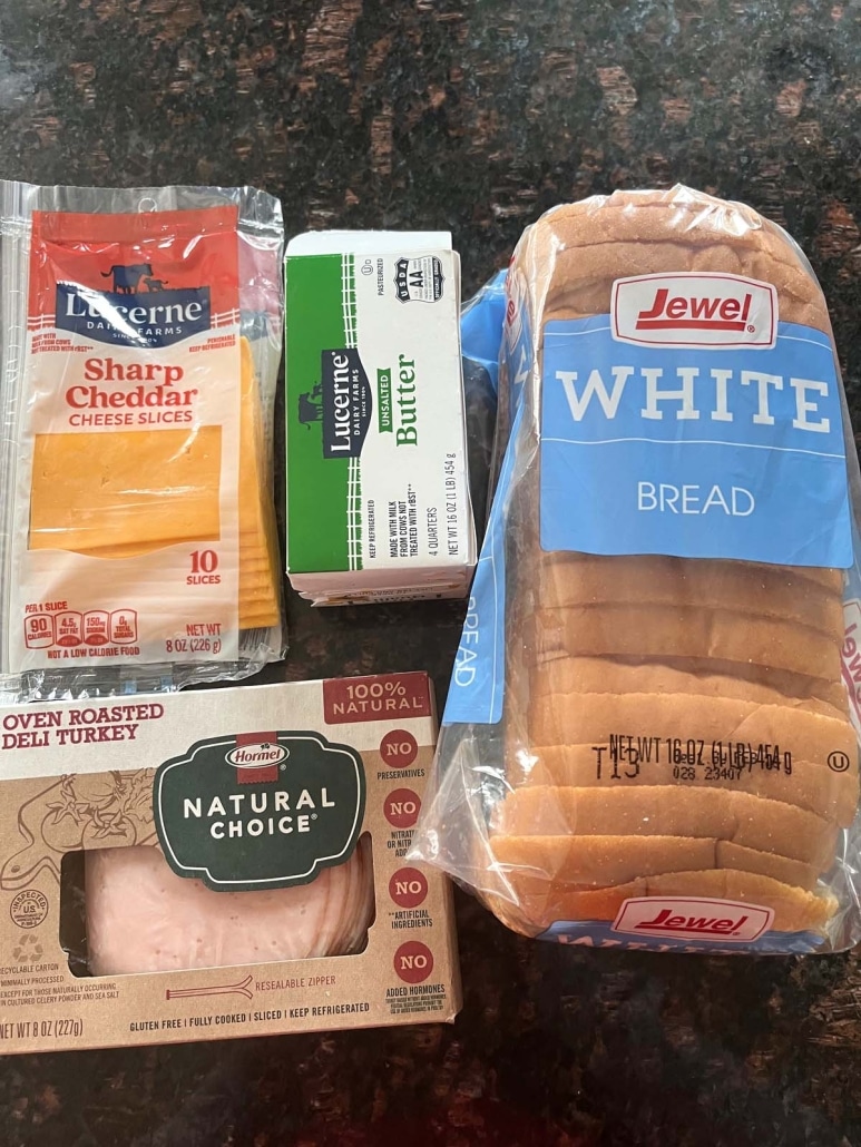 ingredients to make Grilled Turkey And Cheese Sandwich: bread, butter, turkey slices, and cheese slices