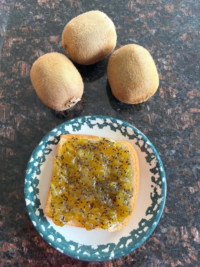3 kiwi fruits next to a slice of toast with kiwi jam on it