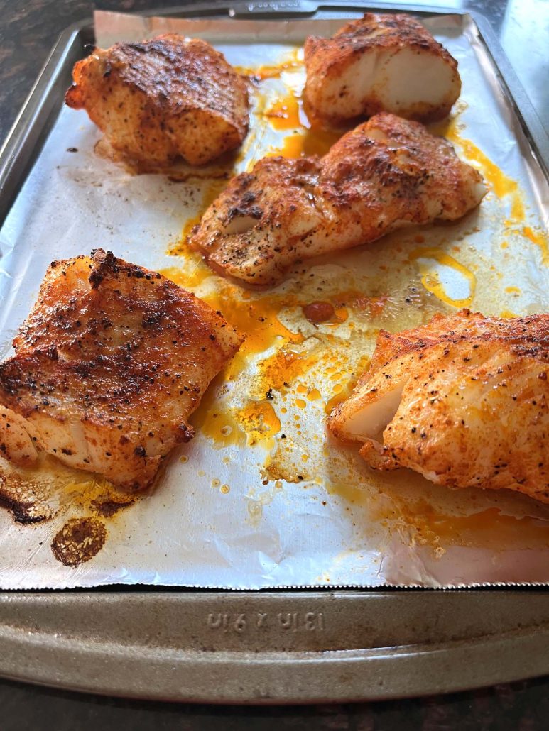 broiled cod fillets on a baking sheet