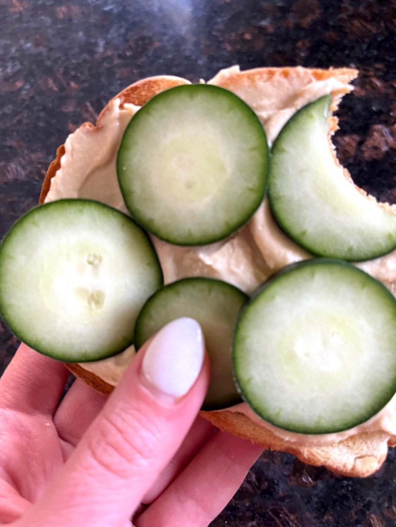hand holding Hummus Toast with a bite out of it