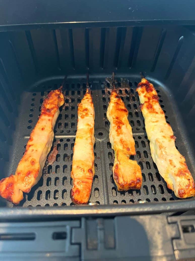 Four juicy Aldi chicken breast skewers cooked in an air fryer, showing a golden-brown, crispy exterior. 