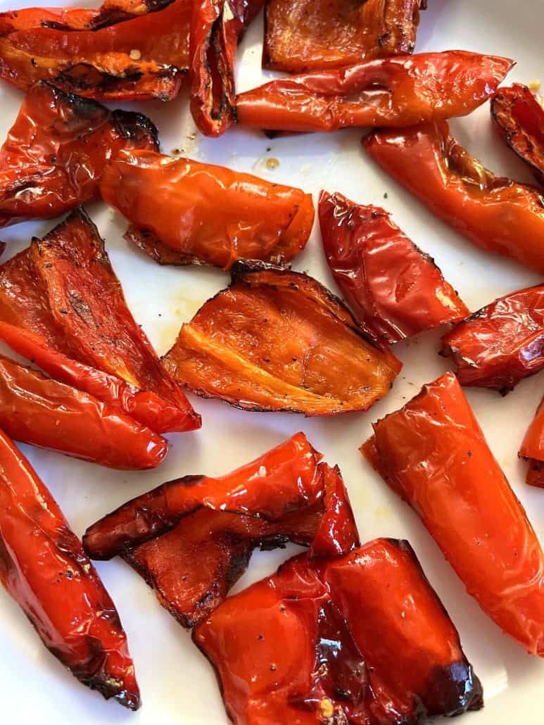 Close-up of slightly charred edges, air-fried ancient red sweet peppers on a plate.