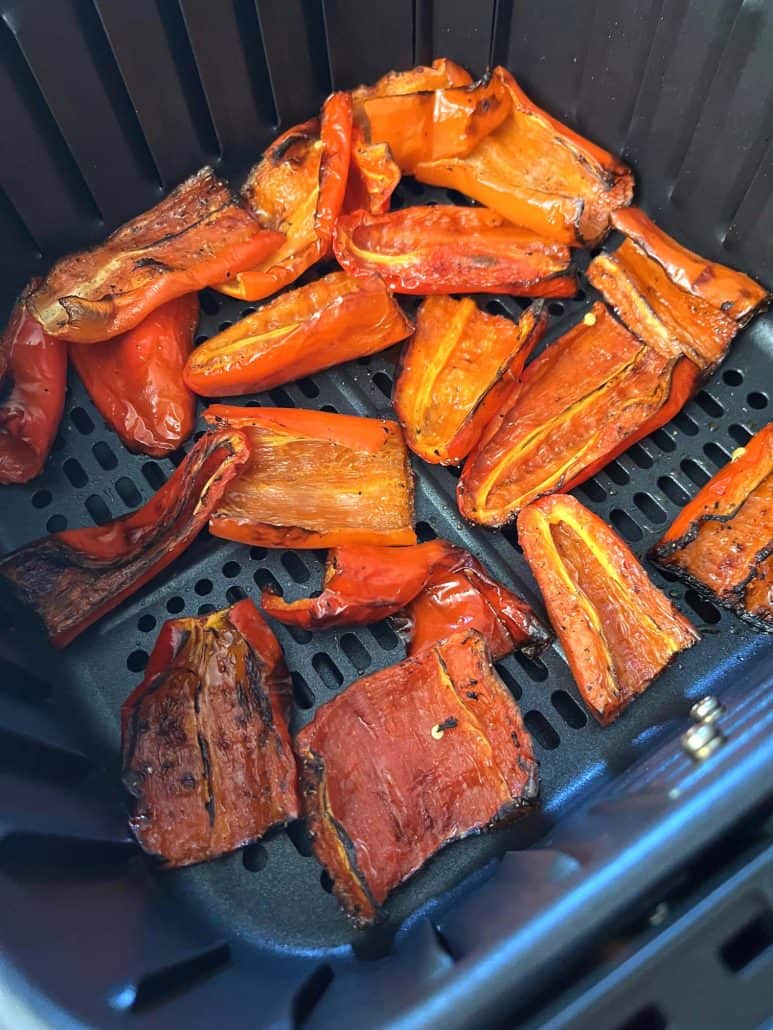 Roasted ancient red sweet peppers in an air fryer basket.