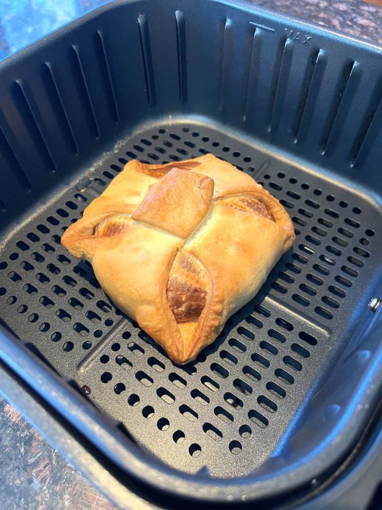 Golden baked brie en croute in the air fryer basket, fresh out.