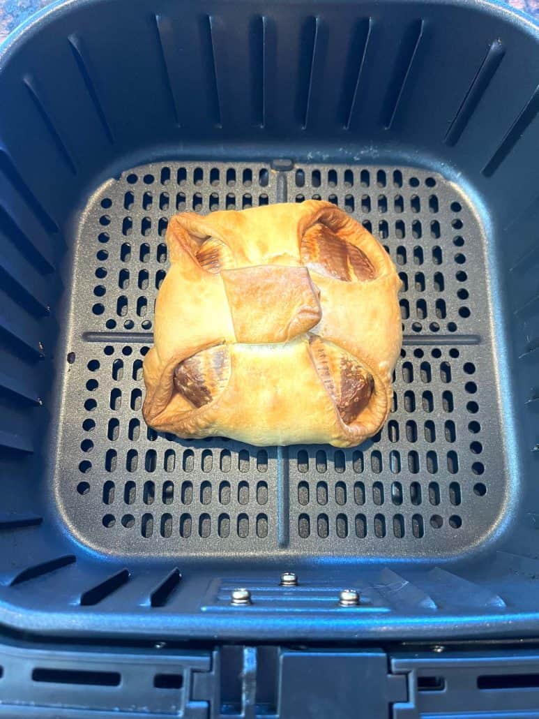 Air fryer cooked brie en croute with golden, flaky pastry fresh and ready to rest before slicing.