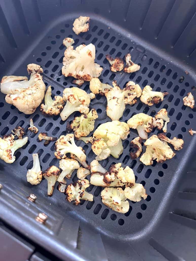 Crispy air-fried frozen cauliflower inside the air fryer basket.