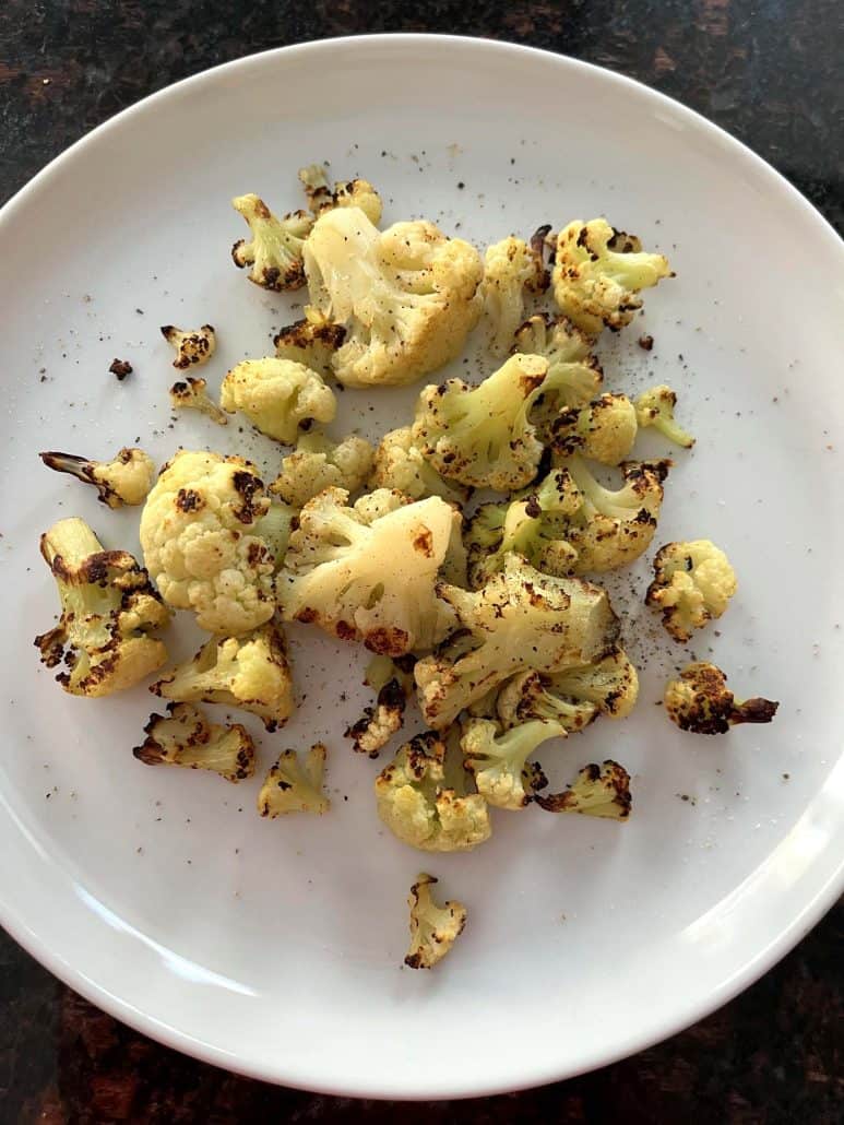 Crispy air fryer cauliflower served on a white plate, showing the perfectly browned florets ready to enjoy as a healthy side dish or snack.