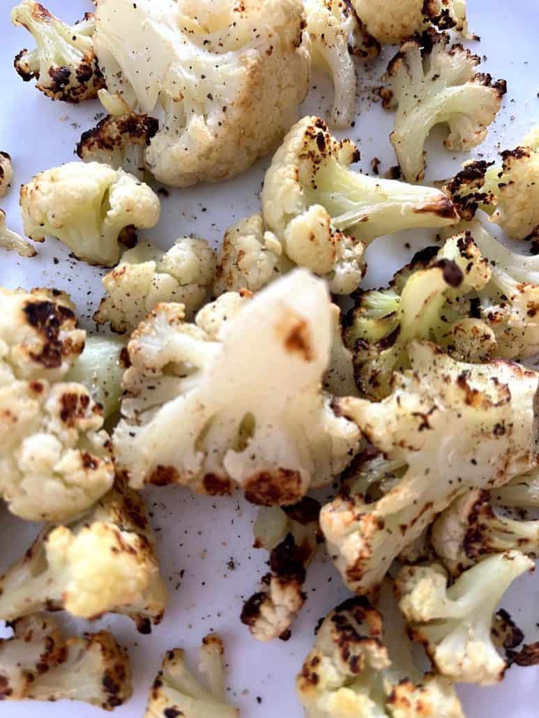 Close-up of roasted air fryer cauliflower on a plate, highlighting the crispy and roasted florets.