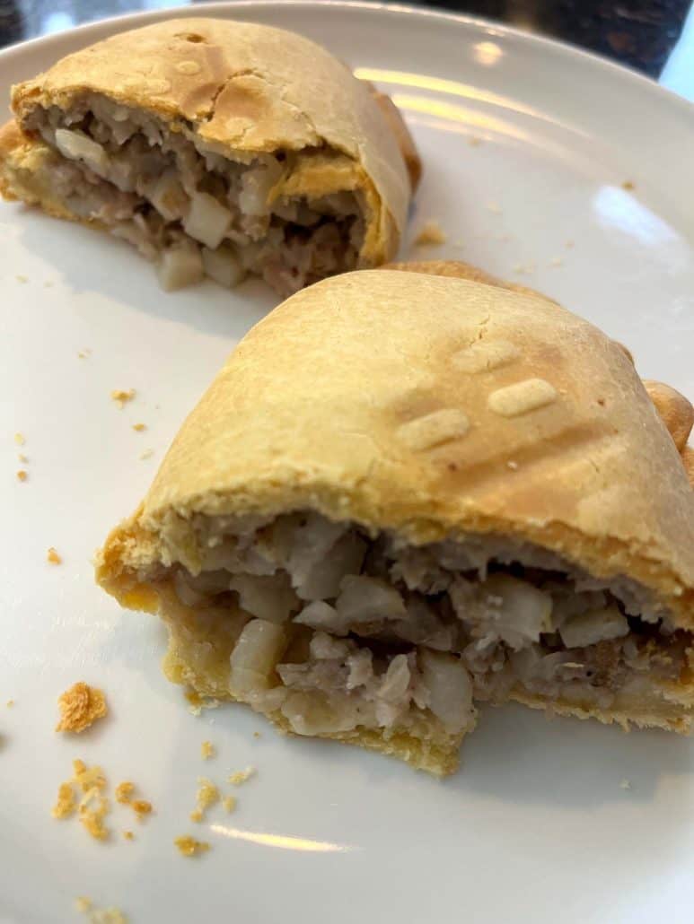 A freshly air-fried pasty cut in half, revealing its hot and savory filling inside.