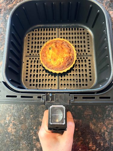 Frozen quiche cooked in air fryer basket, shown perfectly browned and ready to serve—demonstrating the easy air fryer method from the recipe.