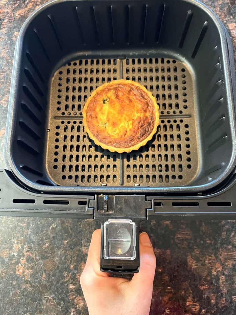Frozen quiche cooked in air fryer basket, shown perfectly browned and ready to serve—demonstrating the easy air fryer method from the recipe.