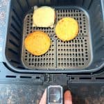 Air fryer basket with separated Jimmy Dean Delights Eggwich components—egg buns and sausage patty cooking to crispy perfection.