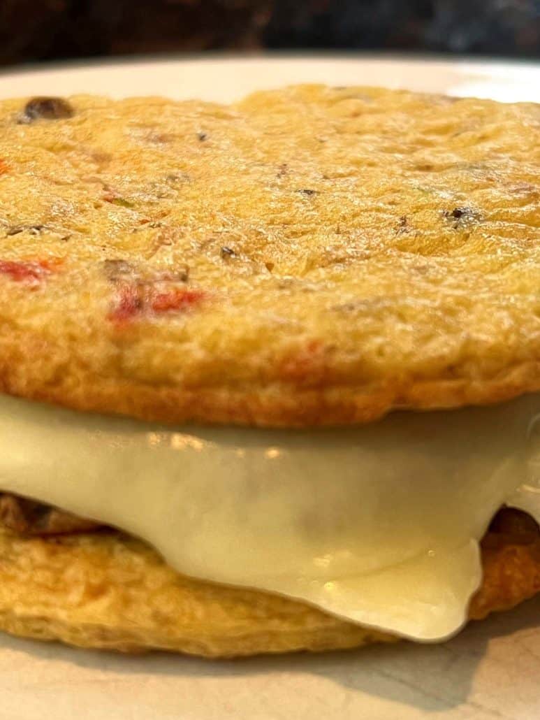 Close-up of a freshly cooked Jimmy Dean Delights Egg’wich with melted cheese, highlighting its crispy egg buns and savory filling for a delicious low-carb breakfast.