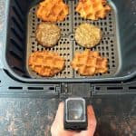Air fryer basket with crispy waffles and sausage patties cooking separately, showing the best way to make Air Fryer Frozen Sausage Waffle Sandwiches for a perfectly crispy texture.