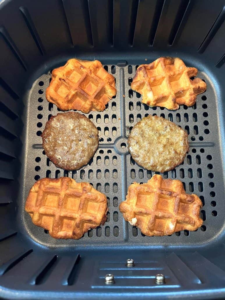 Air fryer basket with Swaggerty's Farm Sausage Waffle Sandwiches separated into waffles and sausage patties.