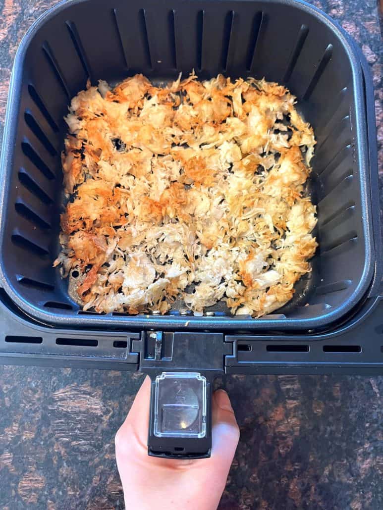 Air fryer filled with crispy, golden-brown shredded chicken breast, perfectly cooked and ready to serve as a delicious lunch or dinner.