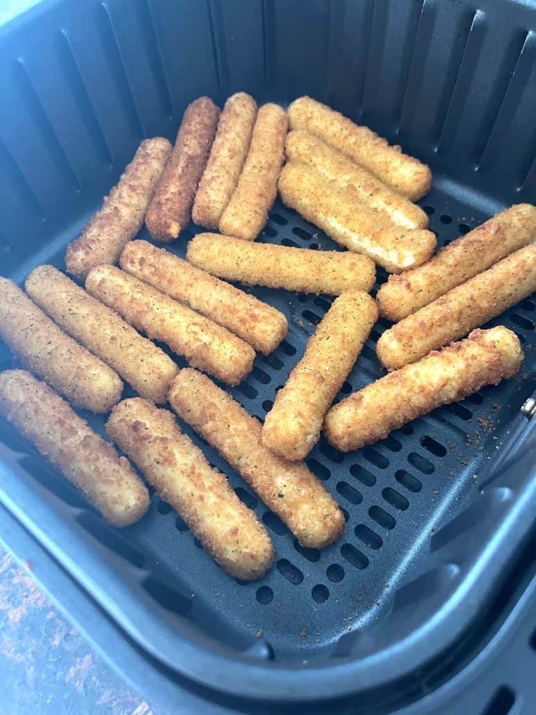 Crispy, golden-brown mozzarella sticks freshly cooked in the air fryer.