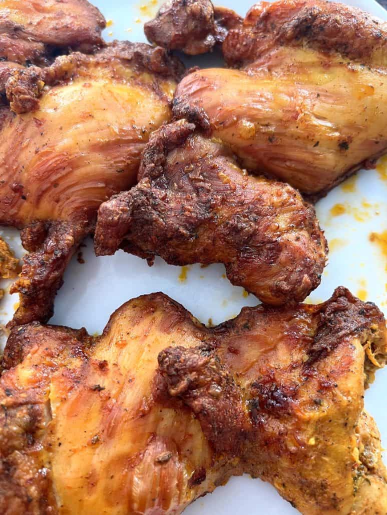 Cooked Trader Joe’s shawarma chicken thighs on a white plate, showing crispy edges and juicy texture.