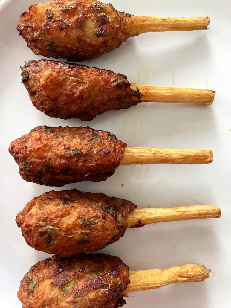 Five perfectly cooked crispy and flavorful appetizer, Trader Joe’s Chao Tom skewers neatly arranged on a plate. 