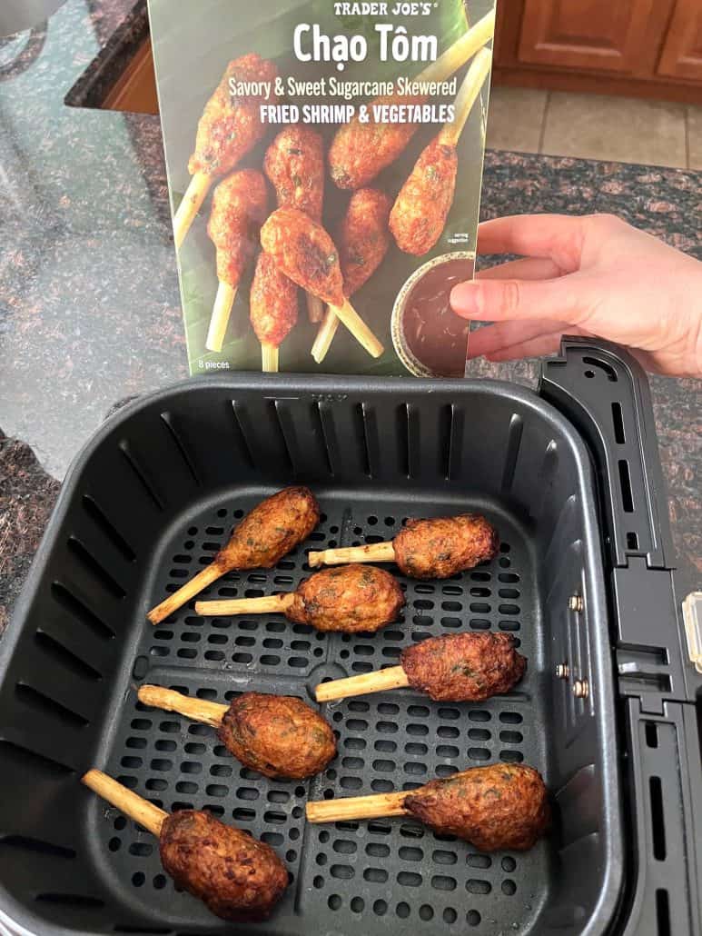 Cooked Trader Joe’s Chao Tom in the air fryer basket with the product box in the background.